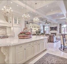 a large kitchen with an island and chandelier hanging from it's ceiling