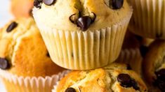 several muffins with chocolate chips on top are stacked up in front of each other