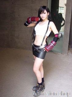 a woman in leather shorts and boxing gloves posing for the camera with her hands on her hips