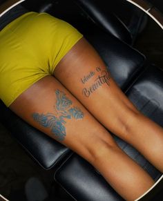 two women with tattoos on their legs sitting in a chair