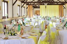 a banquet hall with tables and chairs covered in yellow cloths