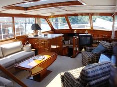 a living room filled with furniture next to a kitchen and dining area on top of a boat