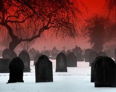 a cemetery with tombstones in the foreground and a red sky behind it at dusk