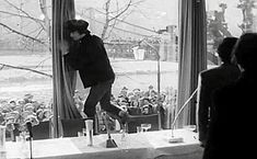 a man standing on top of a table in front of a window