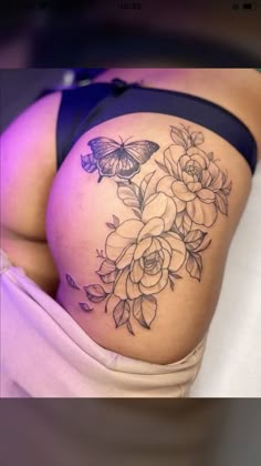 a woman's stomach with flowers and butterflies on it, as well as a butterfly tattoo