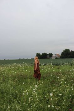 a woman is standing in the middle of a field