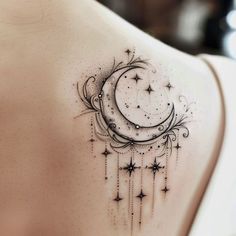 the back of a woman's shoulder with a crescent and stars tattoo on it