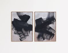 two black and white paintings hanging on a wall