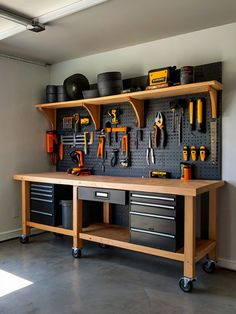 a workbench with lots of tools hanging on it's wall and shelves