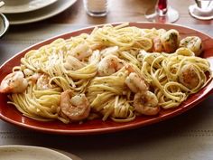 a red plate topped with pasta and shrimp