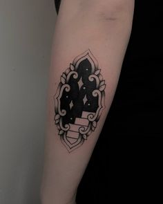 a black and white tattoo on the arm of a woman's left arm with an ornate design