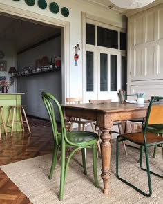 a dining room table with green chairs in front of it