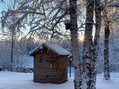 a small cabin in the middle of a snowy forest