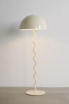 a lamp that is sitting on top of a table next to a white wall and floor