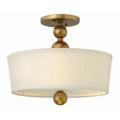 a semi - flush ceiling light with a white shade on the bottom and gold accents