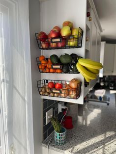 fruit and vegetables are displayed on three shelves in the kitchen, along with two bananas