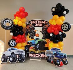 a birthday party with balloons and monster trucks