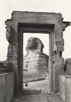 an old photo of the sphinx in front of a doorway with a person standing at the entrance