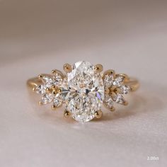 an oval cut diamond ring with three pear shaped diamonds on the band and side stones