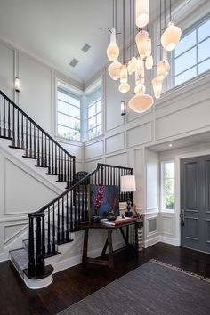 an elegant entryway with stairs and chandelier