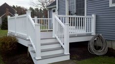 a white porch with steps leading up to the house