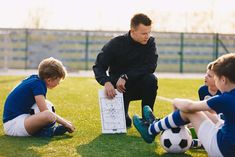 a coach is showing his players how to play soccer on the field stock photo - 959782