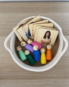 a bowl filled with wooden pegs and pictures