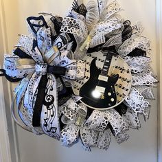 a wreath made out of sheet music notes and an electric guitar is hanging on the front door