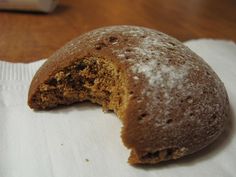 a half eaten doughnut sitting on top of a napkin