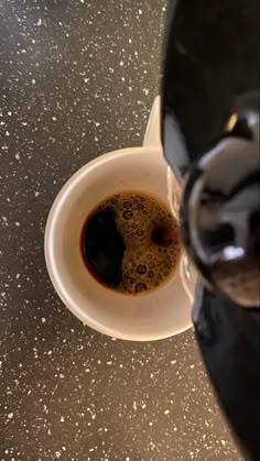 an espresso is being poured into a cup