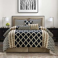 a black and white bed in a bedroom next to a night stand with two lamps