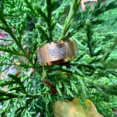 a gold ring sitting on top of a green plant