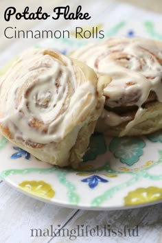 two cinnamon rolls sitting on top of a white and blue plate with the words potato - flake cinnamon rolls