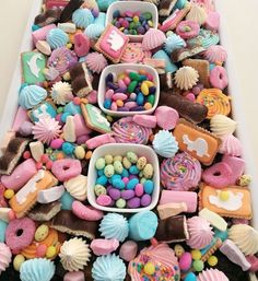 a table topped with lots of different types of cookies and candies on top of each other