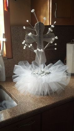 a vase with white flowers in it sitting on top of a counter next to a sink