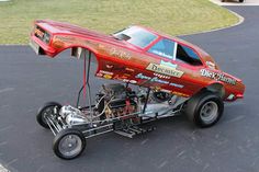 a red car with an engine attached to it's front wheel drive through a parking lot