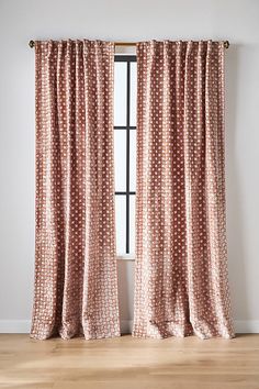 the curtains are hanging on the window sill in front of an empty room with wood floors