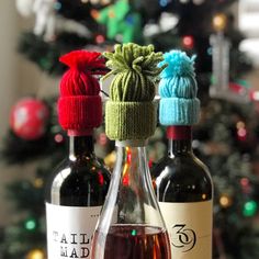 three bottles of wine sitting on top of a table next to a christmas ornament