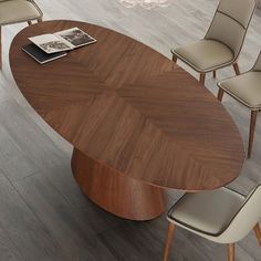 an oval wooden table with beige chairs around it and a magazine on the table next to it