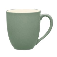 a green coffee cup sitting on top of a white table