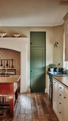 a kitchen with wooden floors and green door