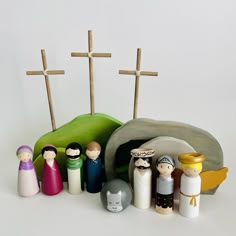 a group of small figurines sitting on top of a white table next to wooden crosses