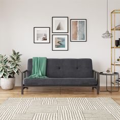 a living room with a couch, rug and pictures on the wall above it in black frames