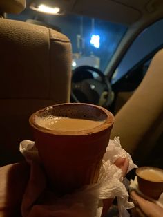 a cup of coffee sitting on top of a napkin in the back seat of a car