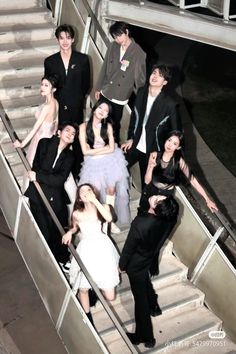 a group of people standing on top of a set of stairs next to each other