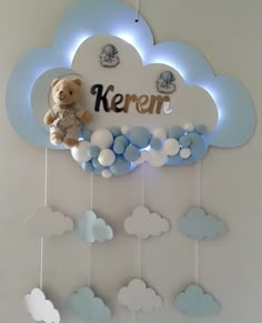 a teddy bear sitting on top of a cloud with the word kerem above it