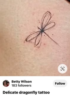 the back of a woman's stomach with a dragonfly tattoo on it