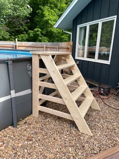 an above ground swimming pool with steps leading up to the bottom and below it is a wooden deck