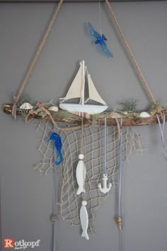 a sailboat and other items are hanging on a wall above a net with hooks