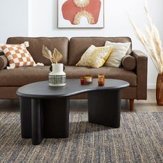 a living room with a couch, coffee table and rug in front of the couch